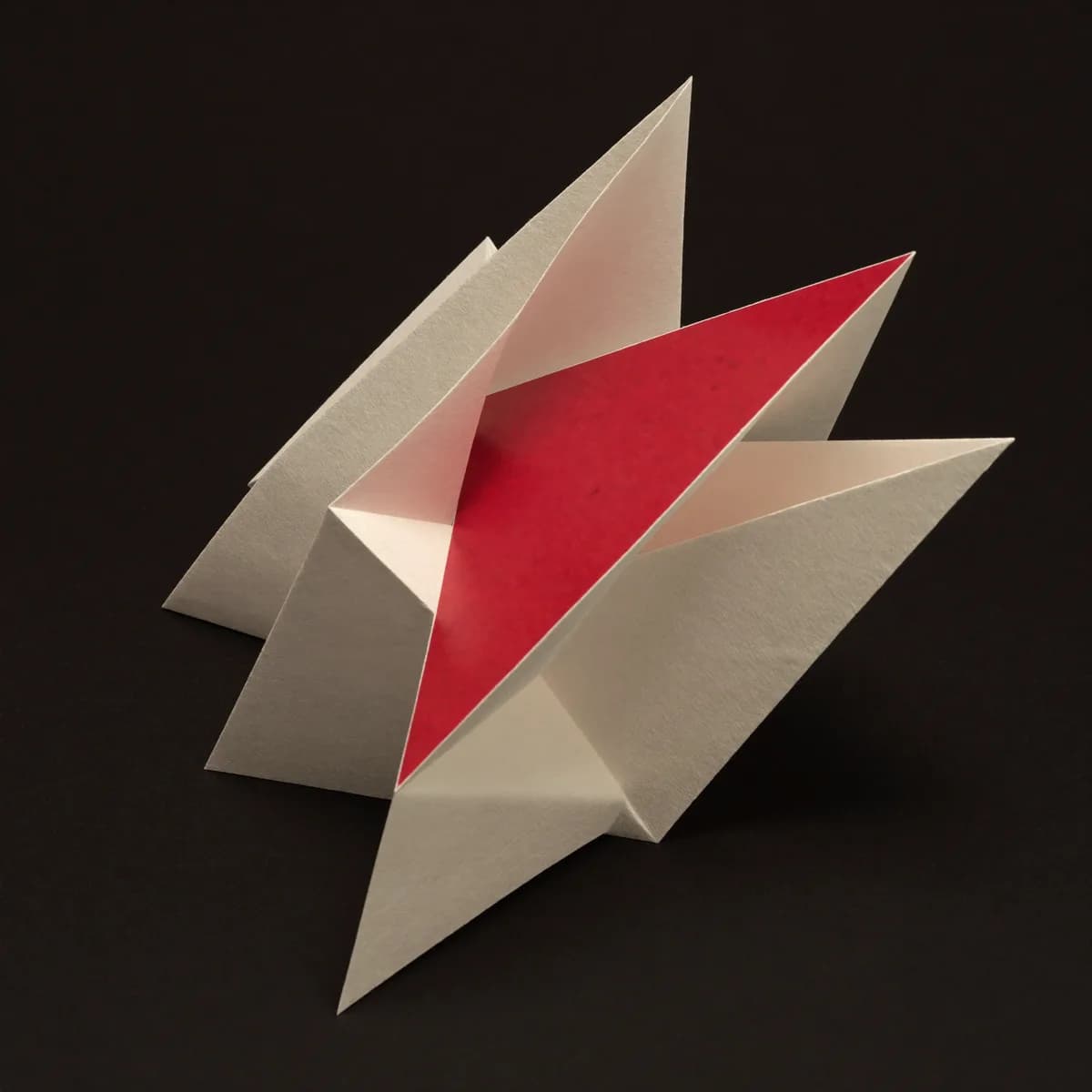 Una escultura de papel plegado en hueso con un plano rojo